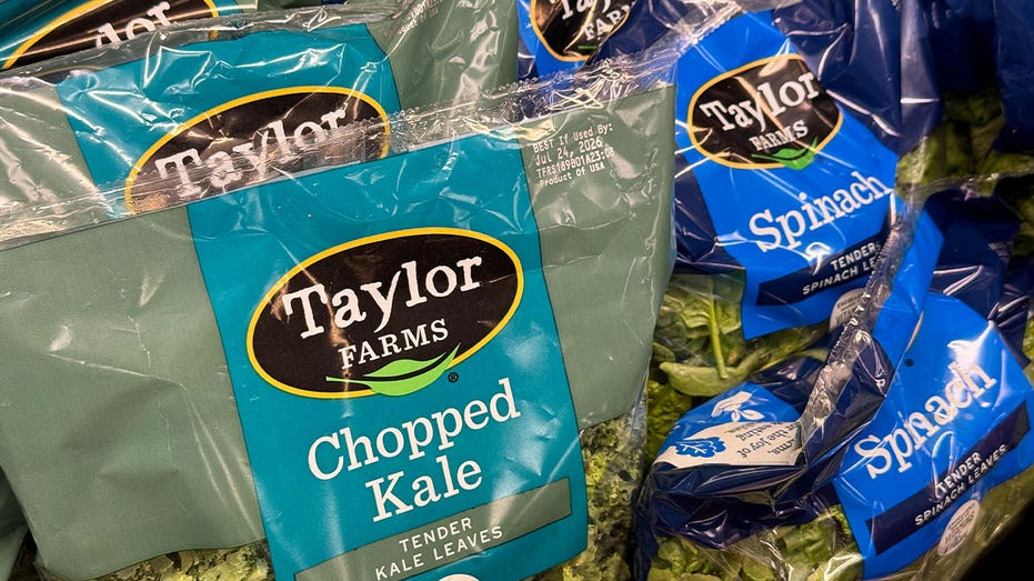 Packages of Taylor Farms salad greens displayed on refrigerated shelves at a Safeway grocery store