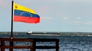 A Venezuelan flag waves in front of oil tanker on lake in Maracaibo, Venezuela on July 27, 2026. The capital of the oil state and surrounding areas offer a stark contrast between Venezuela's oil wealth and the daily reality of communities living near the country's energy infrastructure. While oil continues to generate revenue and crude is shipped through terminals serving international markets, many local residents say they have seen little benefit from the sector. - Fox Business News