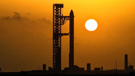 The Starship spacecraft and the Super Heavy v3 booster stand at Pad 2 at sunrise as preparations continue to launch its 13th test flight in Starbase, Texas, U.S., July 24, 2026.  - Fox Business News