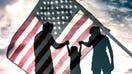 A family is silhouetted with an American flag. - Fox Business News