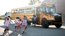 Students run to board a school bus. - Fox Business News