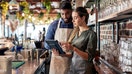 People look at a tablet inside a small business. - Fox Business News