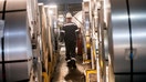 Workers walk past coils of finished steel at the Thyssenkrupp steel mill on March 20, 2025 in Duisburg, Germany.  - Fox Business News