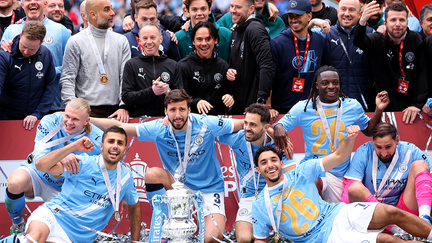 Erling Haaland, Pep Guardiola, Rodri, Ruben Dias, Bernardo Silva, OMar Marmoush, Jeremy Doku and Gianluigi Donnarumma of manchester City celebrate with the trophy after winning the Emirates FA Cup Final match between Chelsea and Manchester City on May 16, 2026 in London, England.  - Fox Business News