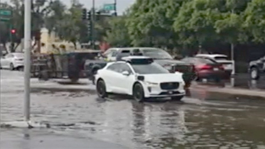 A Waymo vehicle seen on a flooded street.