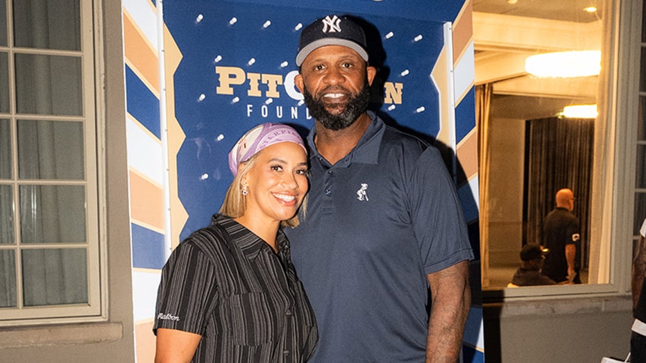 Amber and CC Sabathia smile at golf outing