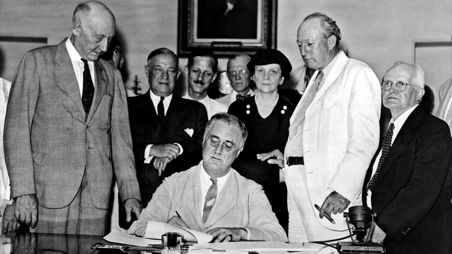Franklin D. Roosevelt signs the Social Security Act into law in 1935.