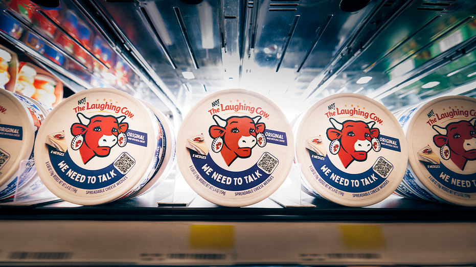 The Not Laughing Cow cheese packages featuring a frowning mascot sit on a refrigerated store shelf