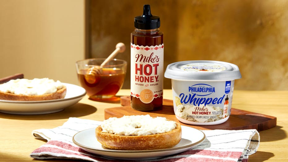 Cream cheese and a bagel on a table.