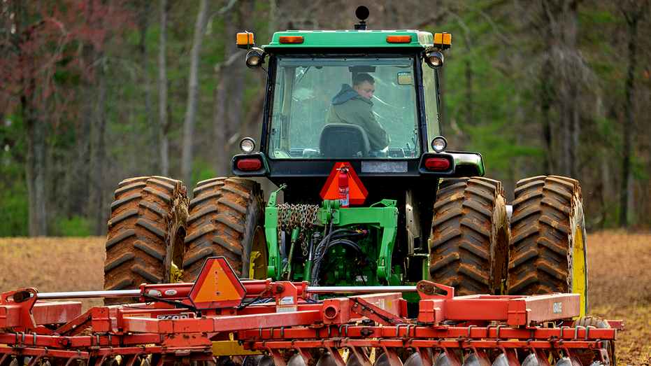 Farm worker tilling a field.