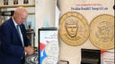 U.S. Treasurer Brandon Beach beside a coin exchange machine and images of both sides of the 2026 Trump dollar coin