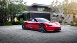 Tesla Roadster in front of a home.