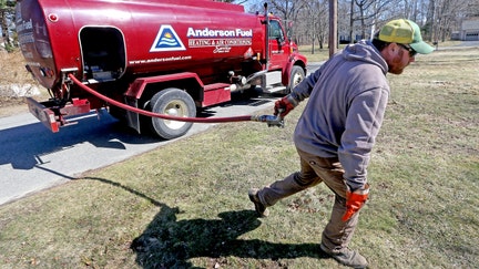 Corey Carlson of Anderson Fuel walks towards a house to fill with home heating oil which has risen to over $5.00 a gallon on March 8, 2022, in Scituate, Massachusetts. - Fox Business News