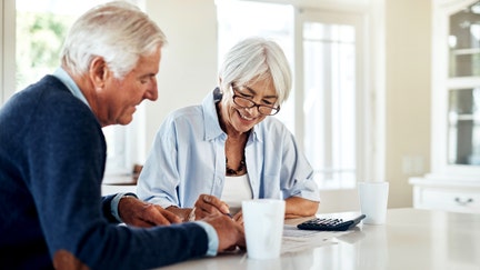 An older couple reviews their finances at their home table. - Fox Business News