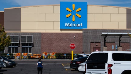 A Walmart employee walks through the customer parking lot near vehicles outside the storefront facade and corporate brand signage in Heber City, Utah, on Oct. 2, 2026. - Fox Business News