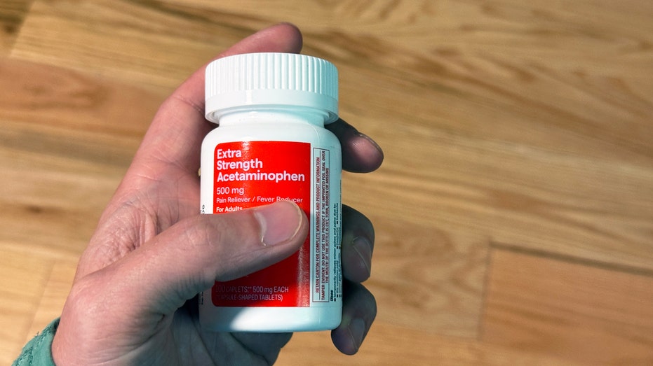 Hand Holding Acetaminophen Drug Bottle