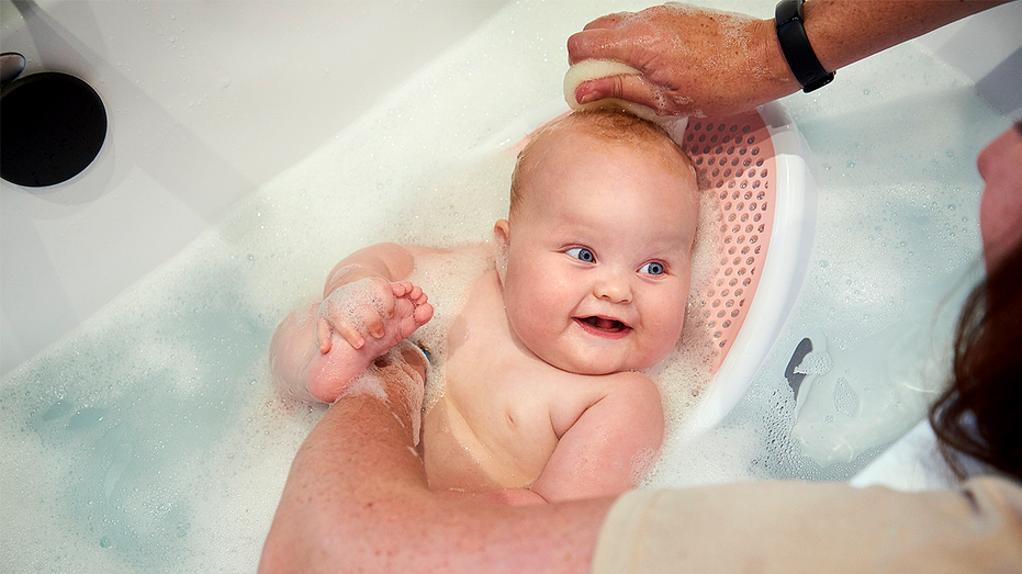 Baby girl in a bath seat