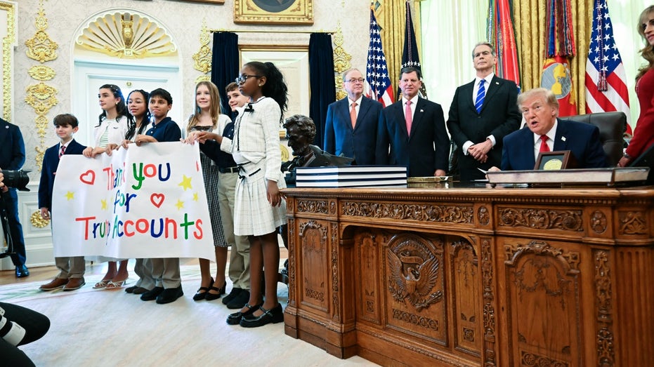 Children hold up banner celebrating Trump Accounts at the White House.