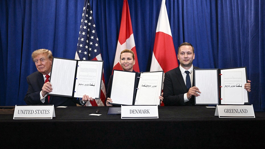 The leaders of the United States, Denmark and Greenland hold up signed agreements.