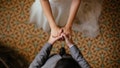 daily news top stories today A close up shot of a bride and groom holding hands from a top view.