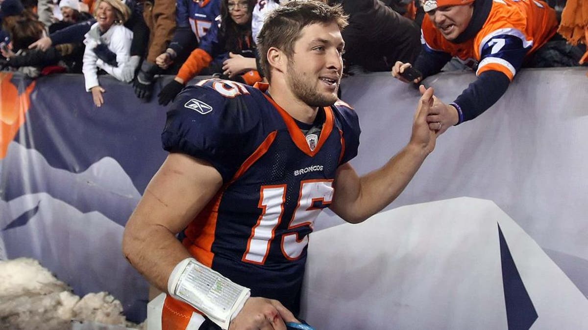 DENVER, CO - JANUARY 08: Quarterback Tim Tebow #15 of the Denver Broncos receives high fives from fans after defeating the Pittsburgh Steelers in overtime of the AFC Wild Card Playoff game at Sports Authority Field at Mile High on January 8, 2012 in Denver, Colorado. The Broncos defeated the Steelers in overtime 23-29. (Photo by Jeff Gross/Getty Images) *** Local Caption *** Tim Tebow