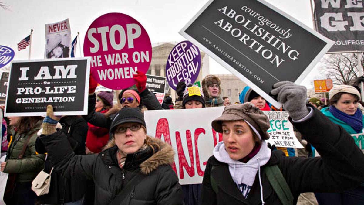 Anti-abortion activists and supporters of legal abortion stand in front of the Supreme Court in Washington, Friday, Jan. 25, 2013, on the 40th anniversary of the Roe v. Wade decision. Thousands of anti-abortion demonstrators marched through Washington to the steps of the U.S. Supreme Court to protest the landmark decision that legalized abortion. (AP Photo/J. Scott Applewhite)