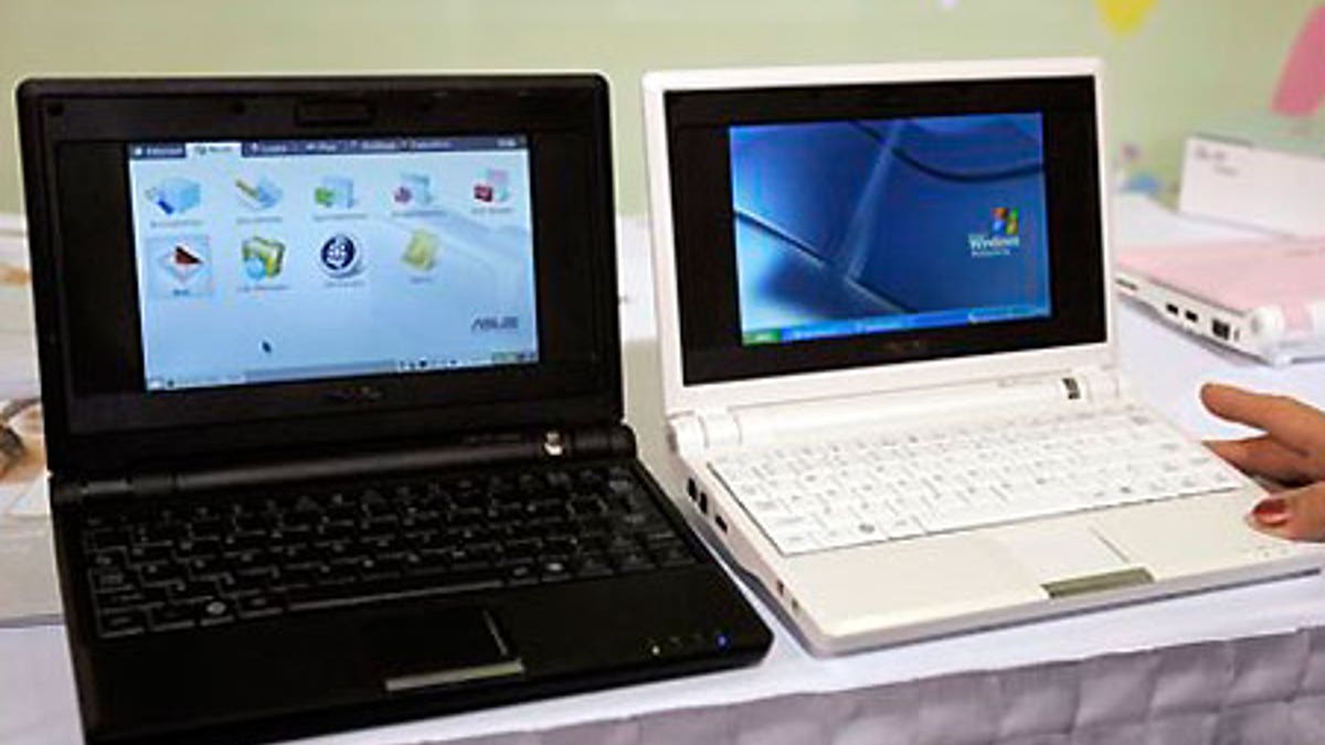 A black Asus Eee PC running Linux and a white one running Windows XP side by side.
