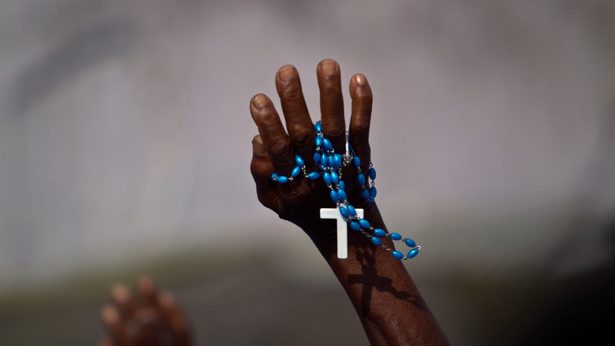 People pray during a procession honoring the Virgin Mary during Notre Dame celebrations at the earthquake damaged national cathedral in Port-au-Prince, Haiti, Monday, Aug. 15, 2011. (AP Photo/Ramon Espinosa)