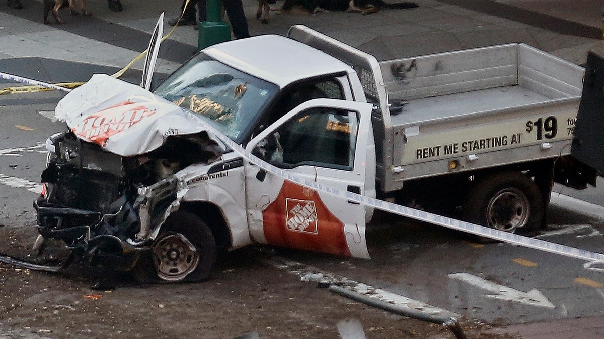 Police tape rests on a damaged Home Depot truck sits after a motorist drove onto a bike path near the World Trade Center memorial, striking and killing several people Tuesday, Oct. 31, 2017, in New York. (AP Photo/Bebeto Matthews)