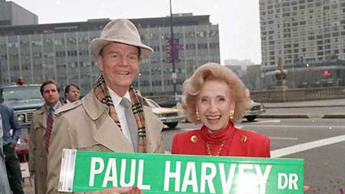Nov. 16, 1988: Radio commentator Paul Harvey and his wife, Lynne, hold a street sign bearing his name in Chicago. A one-block stretch of East Wacker Dr. is changed to Paul Harvey Dr. in honor of the well-known broadcaster. Paul Harvey has died at the age of 90 at his winter home in Phoenix, surrounded by family.