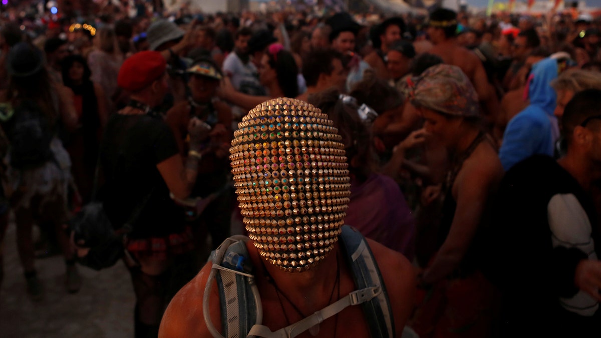 A participant wears a mask as he dances as approximately 70,000 people from all over the world gathered for the annual Burning Man arts and music festival in the Black Rock Desert of Nevada, U.S. August 29, 2017. REUTERS/Jim Urquhart FOR USE WITH BURNING MAN RELATED REPORTING ONLY. FOR EDITORIAL USE ONLY. NOT FOR SALE FOR MARKETING OR ADVERTISING CAMPAIGNS. NO THIRD PARTY SALES. NOT FOR USE BY REUTERS THIRD PARTY DISTRIBUTORS.     TPX IMAGES OF THE DAY - RTX3DXG5