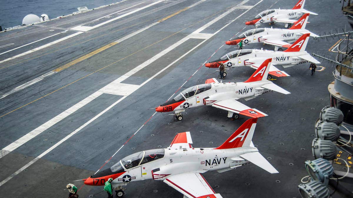 Pilots perform pre-flight procedures for T-45 Goshawks on the flight deck of the aircraft carrier USS George Washington docked in Norfolk, Virginia, on Dec. 10, 2016.