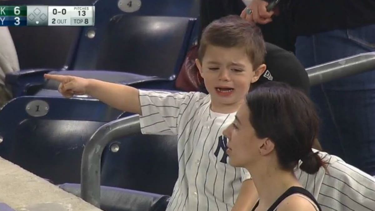 Sad little Yankees fan tries to stop woman from cheering for