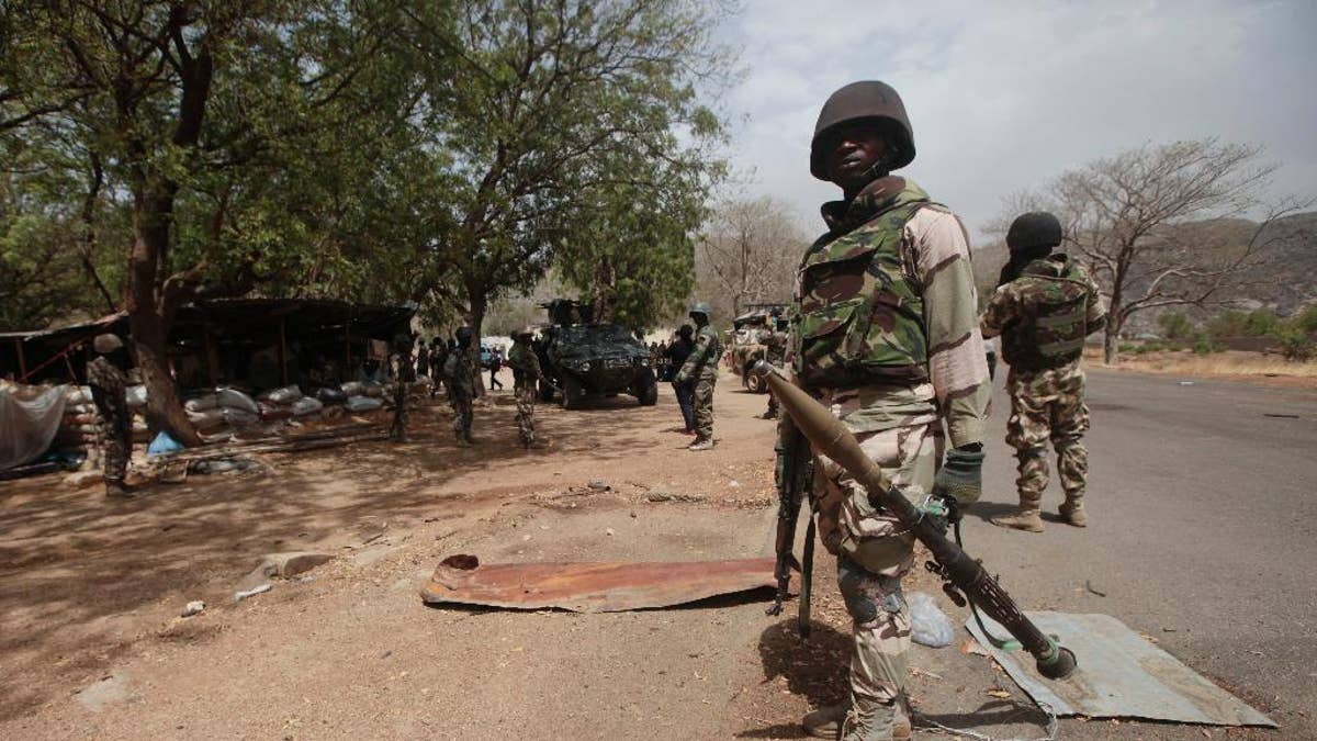 FILE - In this file photo taken Wednesday, April 8, 2015, Nigerian soldiers man a checkpoint in Gwoza, Nigeria, a town newly liberated from Boko Haram. Nigeria's military says troops freed 338 captives, mainly children and women, in raids on Boko Haram camps in northeast Nigeria. Nigeria's Defense Headquarters says 30 militants of the Islamic extremist group were killed on Tuesday Oct. 27, 2015 in attacks on the fringes of the Sambisa Forest. (AP Photo/Lekan Oyekanmi, File)