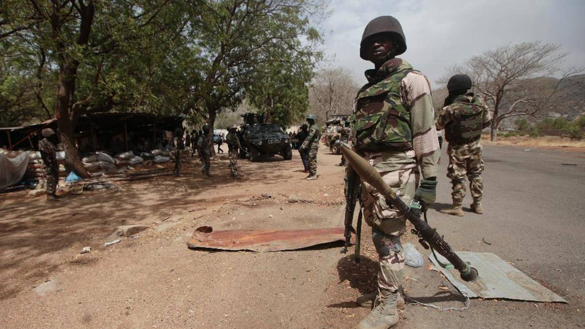 FILE - In this file photo taken Wednesday, April 8, 2015, Nigerian soldiers man a checkpoint in Gwoza, Nigeria, a town newly liberated from Boko Haram. Nigeria's military says troops freed 338 captives, mainly children and women, in raids on Boko Haram camps in northeast Nigeria. Nigeria's Defense Headquarters says 30 militants of the Islamic extremist group were killed on Tuesday Oct. 27, 2015 in attacks on the fringes of the Sambisa Forest. (AP Photo/Lekan Oyekanmi, File)