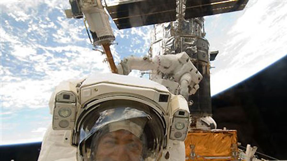 Astronaut Mike Massimino is photographed through a window of the Space Shuttle Atlantis - file photo.