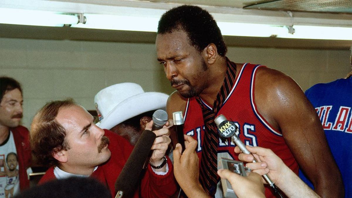 LOS ANGELES - 1983: Moses Malone #2 of the Philadelphia 76'ers gets interviewed by the media after winning the 1983 NBA Championship against the Los Angeles Lakers at the Forum in Los Angleles, California. NOTE TO USER: User expressly acknowledges and agrees that, by downloading and or using this photograph, User is consenting to the terms and conditions of the Getty Images License Agreement. (Photo by Andrew D. Bernstein/ NBAE/ Getty Images)