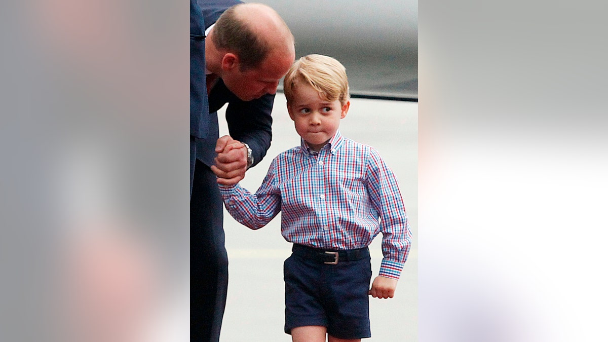 FILE - In this Monday, July 17, 2017 file photo, Britain's Prince William, left, holds the hand of his son Prince George on their arrival at the airport, in Warsaw, Poland. An alleged supporter of the Islamic State group, 32-year-old Husnain Rashid, charged with sharing information about Prince George on social media has denied committing terrorism offenses. (AP Photo/Czarek Sokolowski, file)