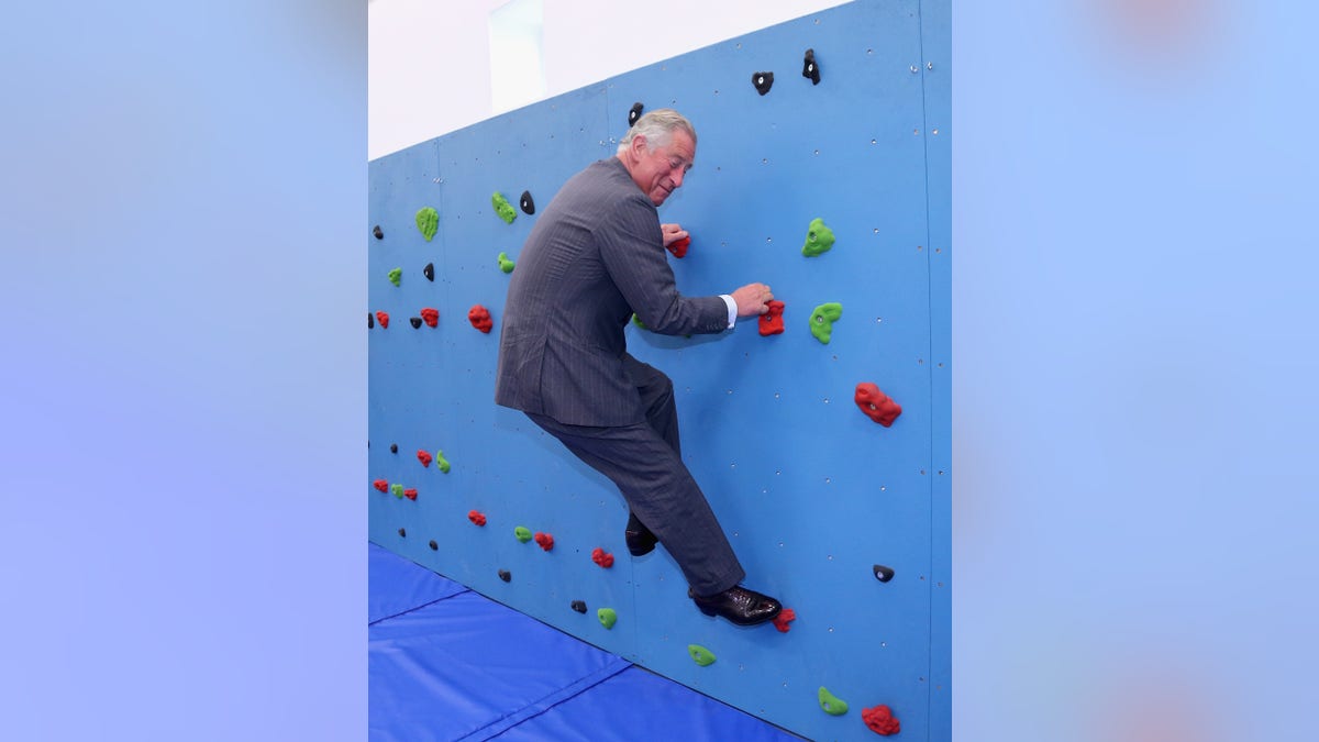 ST HELIER, UNITED KINGDOM - JULY 18: Prince Charles, Prince of Wales climbs on the traversing wall in the new gym at Grainville Secondary School on July 18, 2012 in St Helier, United Kingdom. The Prince of Wales and the Duchess of Cornwall are in Jersey as part of a Diamond Jubilee visit to the Channel Islands taking in Jersey, Guernsey and Sark (Photo by Chris Jackson/Getty Images)