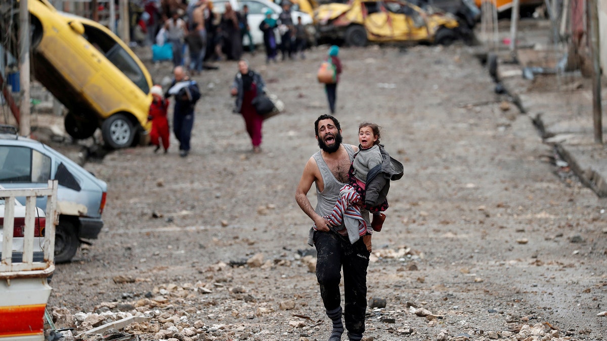 A man cries as he carries his daughter while walking from an Islamic State-controlled part of Mosul towards Iraqi special forces soldiers during a battle in Mosul, Iraq March 4, 2017. Reuters Photographer Goran Tomasevic: 