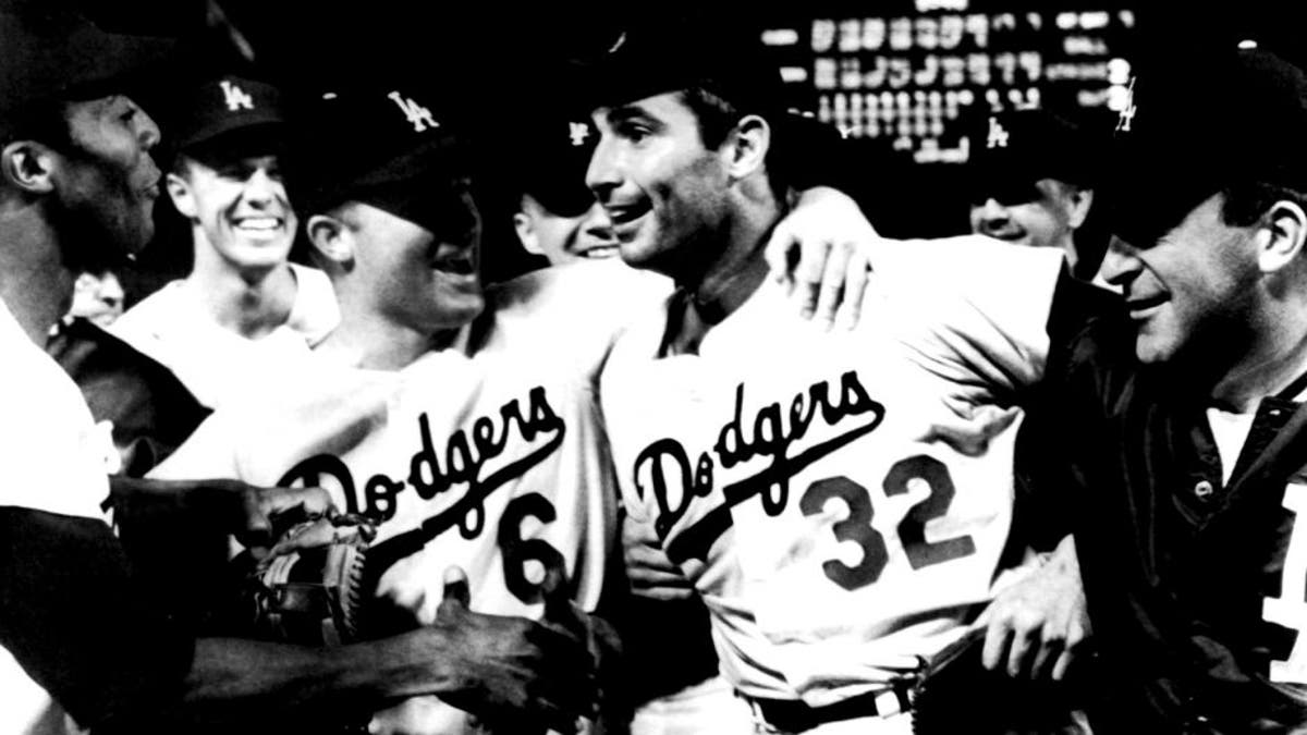 Sandy Koufax, center, of the Dodgers is rushed by teammates as he leaves  the mound after pitching a perfect game, no batter reached first, against  the Chicago Cubs, Sept. 10, 1965, Los