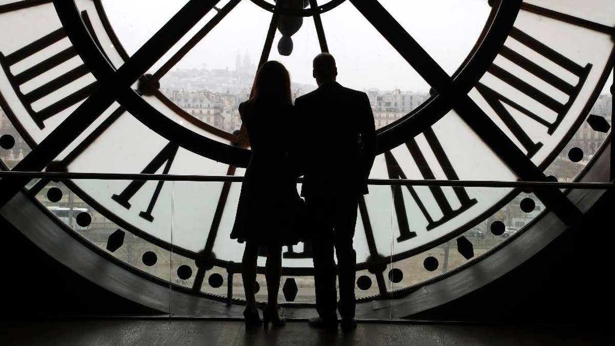 Britain's Prince William, Duke of Cambridge, and his wife Britain's Kate, Duchess of Cambridge, are silhouetted as they look the Seine river through a giant clock at the Musee d'Orsay museum -the former Gare d'Orsay train station- during their visit to the museum, Saturday, March 18, 2017, on the second day of their two-day visit to the French capital. (Francois Guillot/Pool Photo via AP)