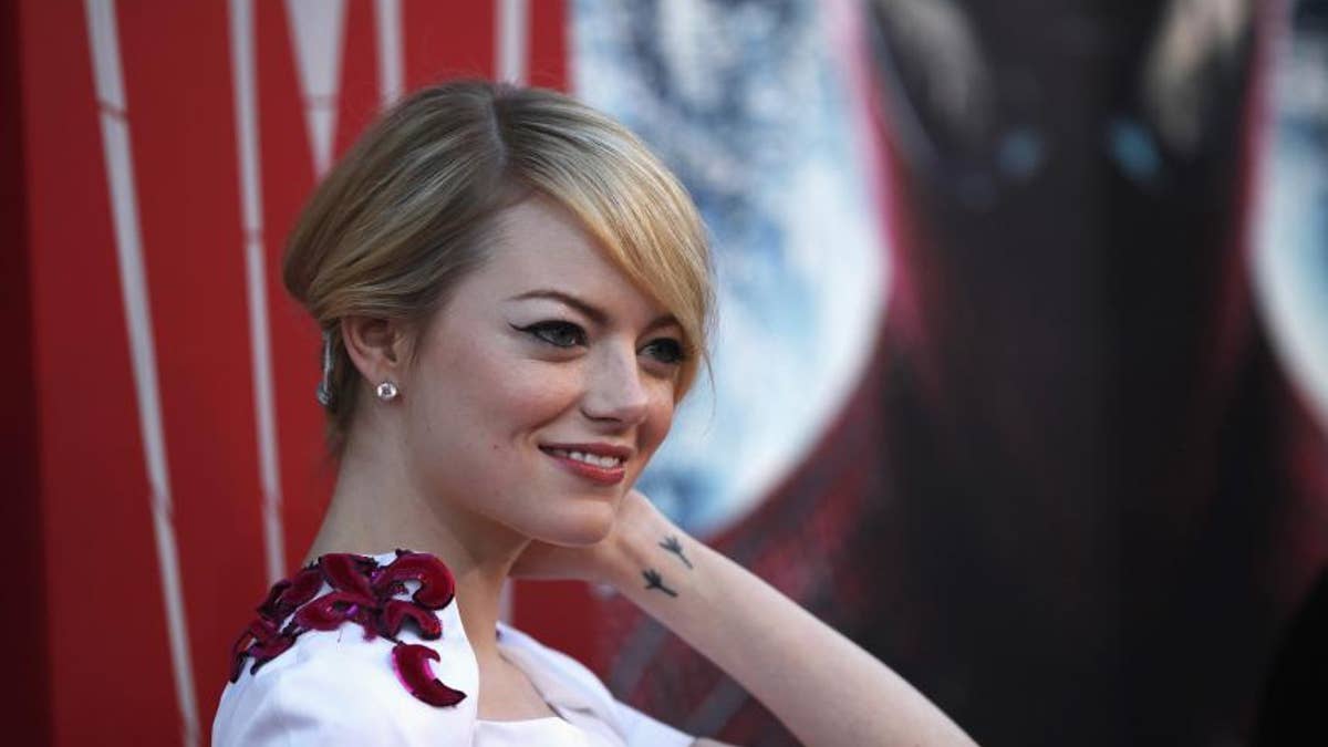 Emma Stone smiles on a red carpet