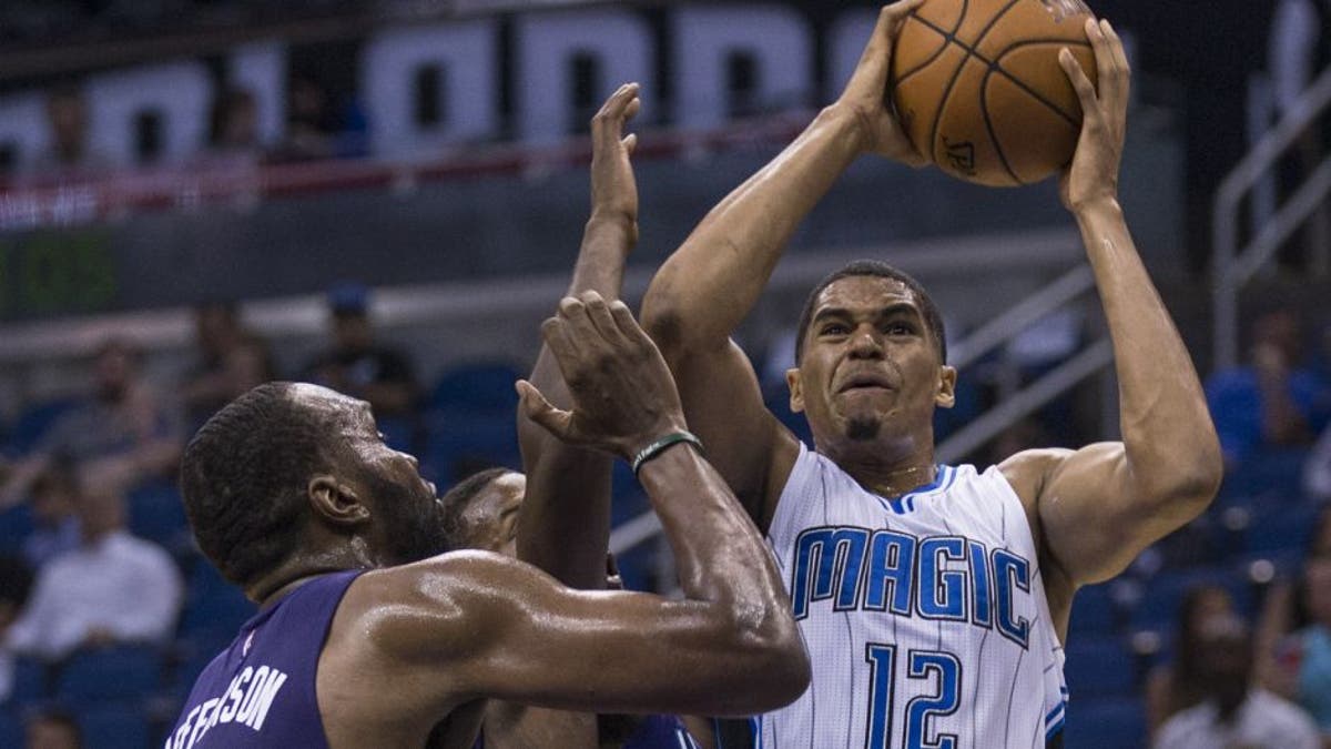 Orlando Magic forward Tobias Harris (12) shoots the ball and scores over Charlotte Hornets forward Sam Thompson (12) center and Charlotte Hornets center Al Jefferson (25) right, during the first half of an NBA basketball game in Orlando, Fla., Saturday, Oct. 3, 2015. (AP Photo/Willie J. Allen Jr.)