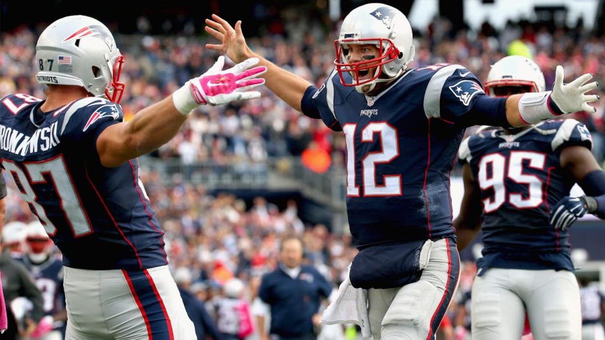 FOXBORO, MA - OCTOBER 25: Tom Brady #12 and Rob Gronkowski #87 of the New England Patriots react after Gronkowski scored a touchdown during the fourth quarter against the New York Jets at Gillette Stadium on October 25, 2015 in Foxboro, Massachusetts. (Photo by Jim Rogash/Getty Images)