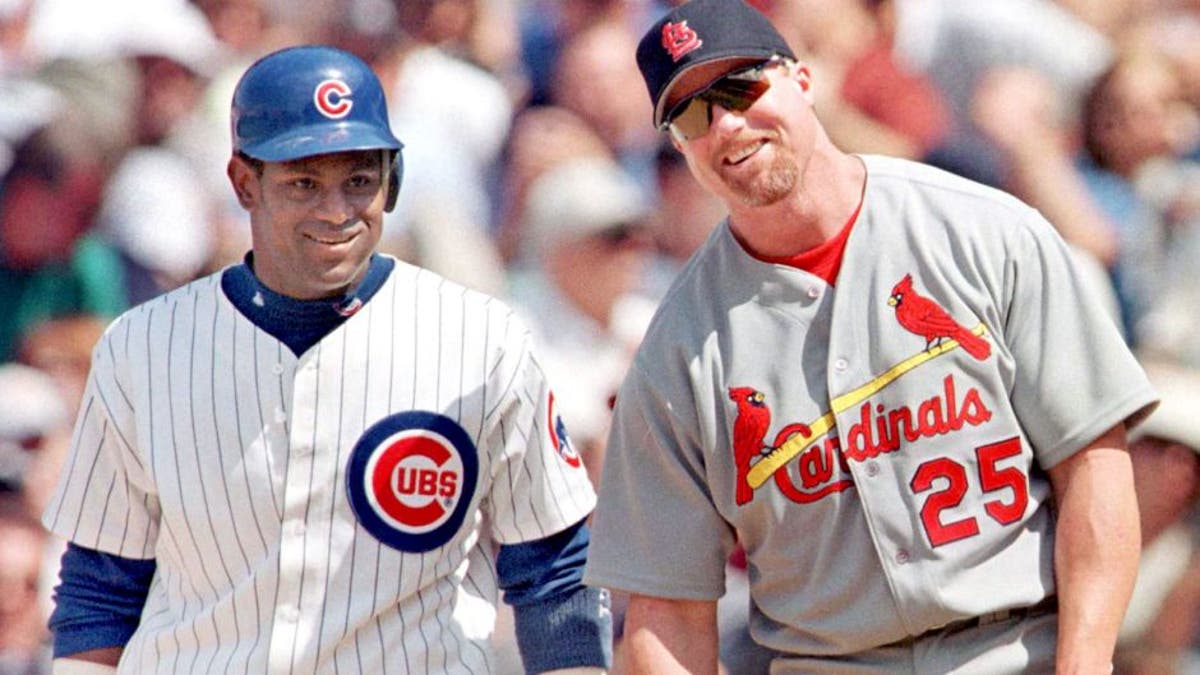 CHICAGO, UNITED STATES: The Chicago Cubs' Sammy Sosa stands with St. Louis Cardinal's first baseman Mark McGwire between pitches after Sosa singled in the second inning 28 May, 1999, at Wrigley Field in Chicago, Illinois. It was the first time the pair had played each other since last year's home run race. The Cubs won 6-3 with help from a home run from Sosa. AFP PHOTO/John ZICH (Photo credit should read JOHN ZICH/AFP/Getty Images)