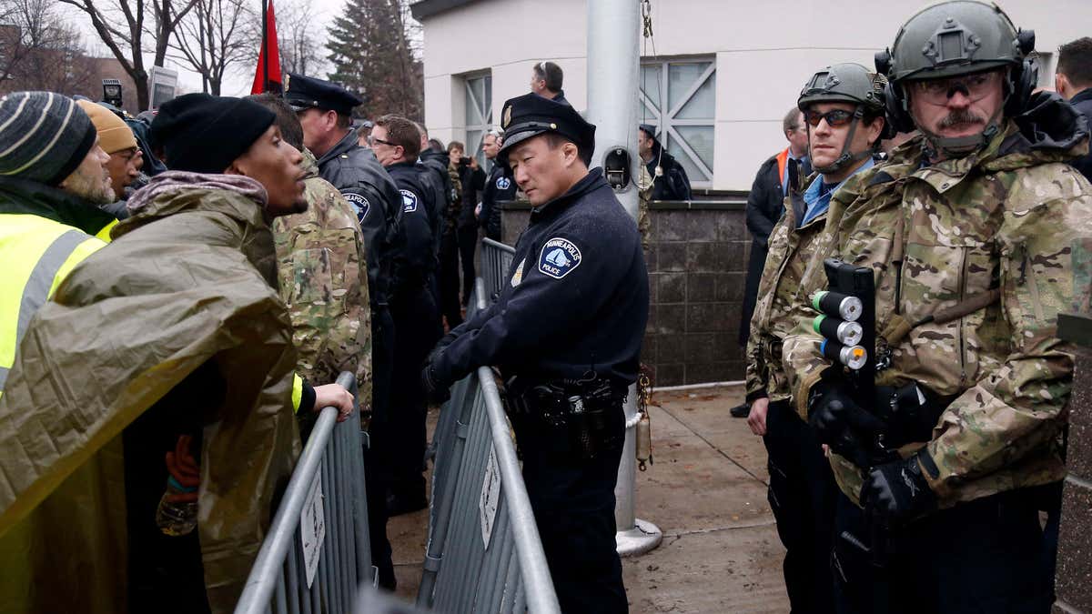 Nov. 18, 2015: A Black Lives Matter supporter, left, talks to Minneapolis police guarding the Fourth Precinct entrance in Minneapolis.