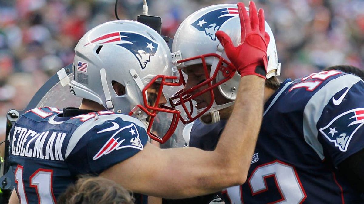 Dec 14, 2014; Foxborough, MA, USA; New England Patriots wide receiver Julian Edelman (11) celebrates with quarterback Tom Brady (12) after scoring a touchdown during the third quarter against the Miami Dolphins at Gillette Stadium. Mandatory Credit: Stew Milne-USA TODAY Sports