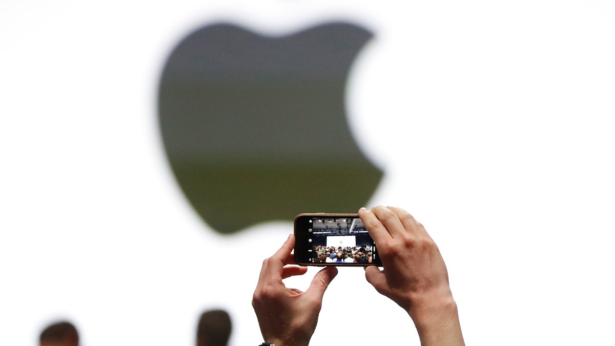 An audience member takes a photo of the Apple logo before the start of the company's annual developer conference in San Jose, California, U.S. June 5, 2017. REUTERS/Stephen Lam - RTX3959D