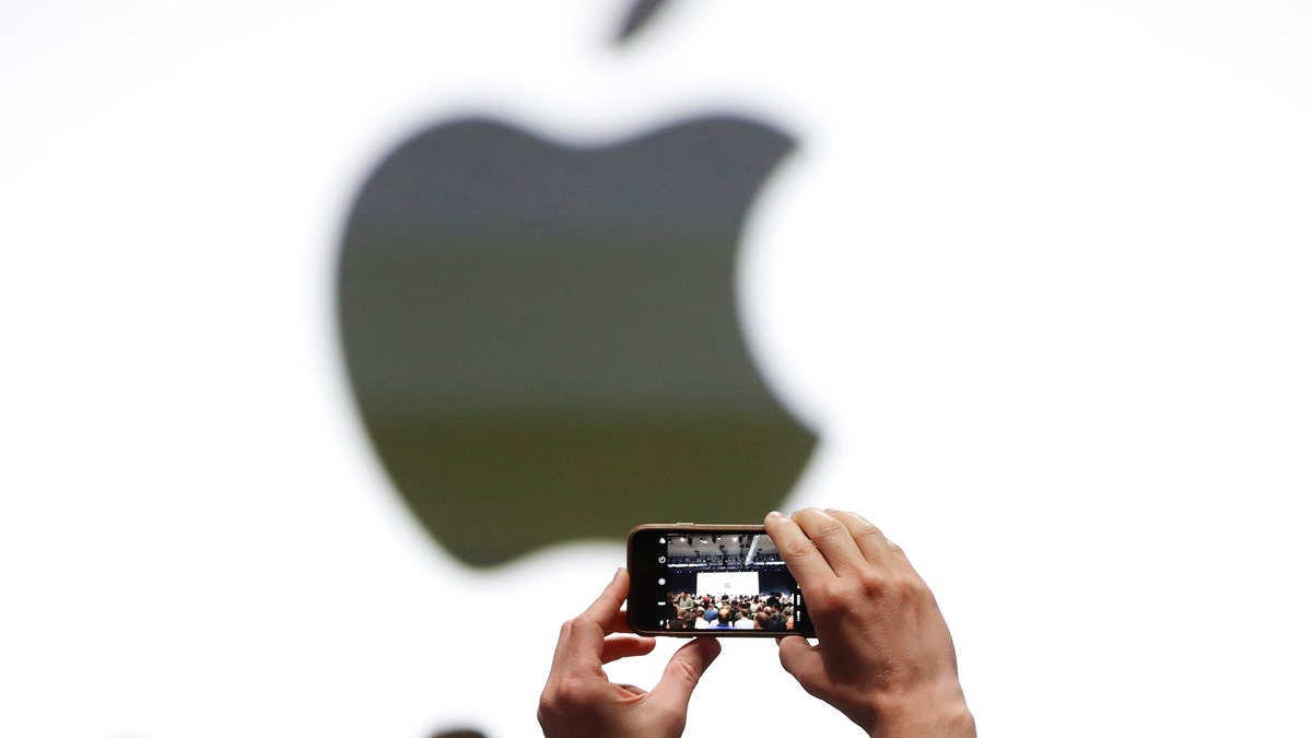 An audience member takes a photo of the Apple logo before the start of the company's annual developer conference in San Jose, California, U.S. June 5, 2017. REUTERS/Stephen Lam - RTX3959D